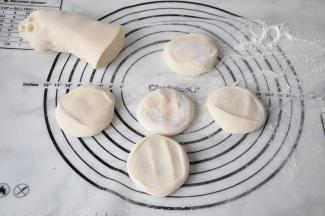 配好的面团分割成小段轻按扁。我一般分割成55-60克的面团，这个大小正好适合我家的锅，拿着食用起来也方便。