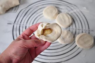 取一块油酥放在面团上。