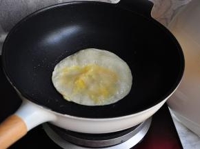 调成小火，用筷子将饼戳破，快速将提前打散的蛋液倒入并使其均匀。
