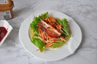 再放上提前焯好的土豆丝、胡萝卜丝、生菜、烤鸡柳、火腿肠等食材，卷起来就可以食用了。