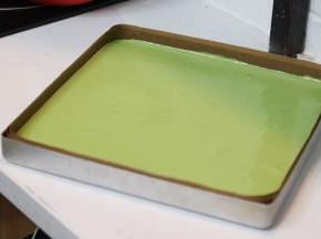 12.	倒入提前铺好油纸的烤盘中，如果面糊状态对的话只需要轻磕几下表面就可以自然流平了。放入预热好的烤箱中层190℃烘烤20分钟