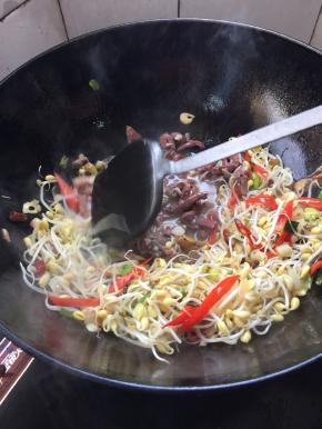 把袋装羊杂倒入锅里翻炒均匀。