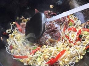 把袋装羊杂倒入锅里翻炒均匀。