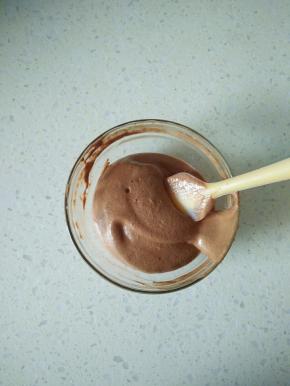 取20克蛋白霜分次加入到可可糊里翻拌均匀，装入裱花袋。