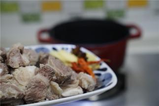 预热好珐琅锅，先将生姜信息角辣椒下锅炒出香，再将焯洗好的牛腩下锅炒至微微有点干。