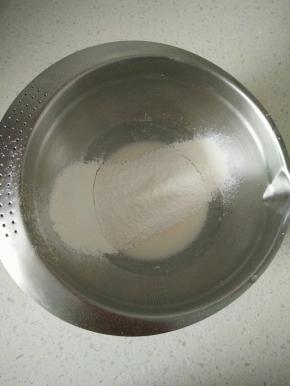 牛奶和玉米油到入打蛋盆里，用手动打蛋器搅拌均匀，颜色发白看不到油花，筛入低粉。