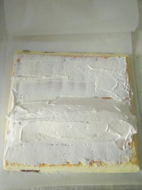 再把蛋糕卷倒扣，正面朝上，两端用锯齿刀斜切，抹上奶油，两端少中间多。