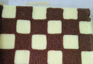 取出油布，底部铺一张油纸，倒扣蛋糕卷，撕掉油布出现毛巾面，为了不让水分流失，表面盖一层油纸。