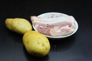 准备食材：土豆2个、五花肉300克、大葱、油、盐、生抽、生姜、料酒、八角、高汤。