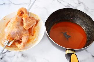 把腌制好的三黄鸡取出用烤箱转叉叉住，然后把剩下的腌料倒入中，加入蜂蜜，放在炉上煮沸关火