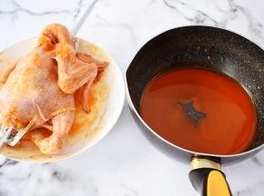 把腌制好的三黄鸡取出用烤箱转叉叉住，然后把剩下的腌料倒入中，加入蜂蜜，放在炉上煮沸关火