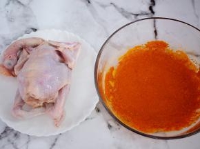 把三黄鸡清洗干净控干水分备用，奥尔良腌料加入30克纯净水拌匀