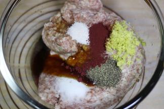 加入姜末，黑胡椒粉，红曲粉，盐，糖耗油，鲜味汁和料酒，顺着一个方向搅拌