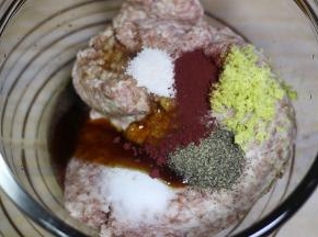 加入姜末，黑胡椒粉，红曲粉，盐，糖耗油，鲜味汁和料酒，顺着一个方向搅拌