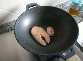 锅子烧热，倒入食用油，放入三文鱼，盖上锅盖