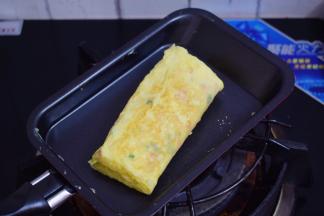从另一边慢慢卷回来，依次这样，直至鸡蛋液用完，最后双面各煎一下定型，即可出锅切块食用
