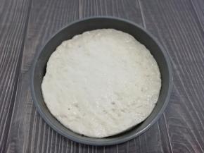 发酵好的面团，取出排气后松弛一下，擀成圆形。披萨盘中抹一层油，放入面饼，按披萨盘的大小，整理一下形状