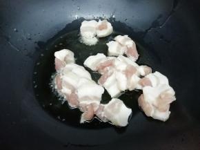 锅中加入适量的油烧到七成热时，把五花肉放入锅中煸出油