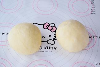 取出面团排气后，平均分成2份，滚团盖保鲜膜松弛20分钟