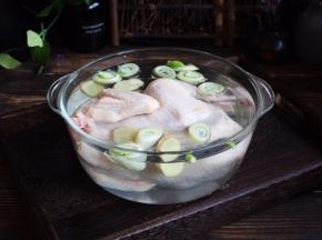 然后给三黄鸡去腥，去腥时用凉水浸泡，浸泡时放入2勺的米酒，放适量的姜片和葱段，浸泡至少半个小时。