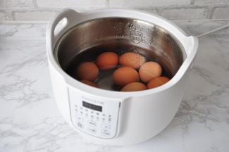 先将鸡蛋洗净提前煮熟。鸡蛋我也是用的炖锅，选择其中一个功能键，待锅中水沸即可关掉，在锅中闷上十分钟即可。这样做，能很好的节省能源。如果您是在燃气灶上煮，也可以用同样的方法，水沸即关火，在锅中焖。