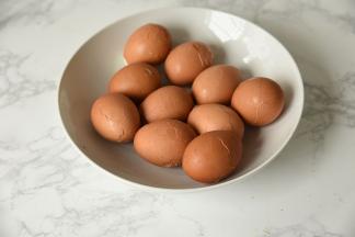 将煮熟的鸡蛋捞出过凉，然后将鸡蛋均匀的敲碎外壳。外壳敲成碎而相连的状态就行。这样的花纹待茶蛋煮好后，每个花纹不同，每个都有特色