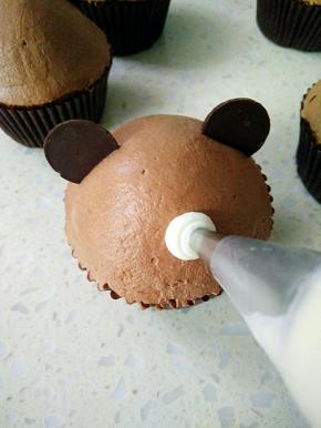 在蛋糕上挤个圆球，贴上巧克力鼻子、眼睛。