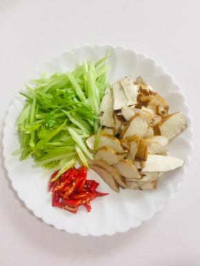 西芹洗净切成片，香干顶刀斜切成薄片，红辣椒切成块儿备用。