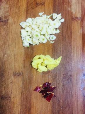 蒜瓣剥皮剁碎，生姜切成小丁，干辣椒切成段儿备用。