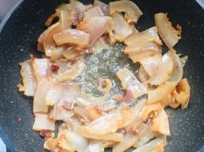 锅烧热，放入腊肉煸炒至出油。