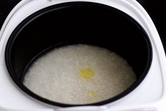 把大米和糯米混合在一起洗净后，放入电饭煲里，加入适量的清水，少滴点食用油，这样做出来的米饭非常香浓可口，启动电饭煲的精煮模式。