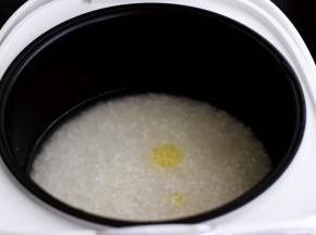 把大米和糯米混合在一起洗净后，放入电饭煲里，加入适量的清水，少滴点食用油，这样做出来的米饭非常香浓可口，启动电饭煲的精煮模式。