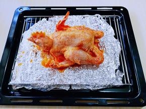 烤网垫上锡纸，再把腌制好的鸡放烤网上。（我把鸡做了个造型，在鸡脖子那里插了两根牙签，使鸡看起来像是趴在那里）