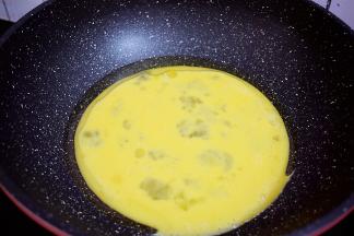 锅中倒入适量的食用油烧热，倒入鸡蛋液，用筷子快速搅拌成鸡蛋小碎块