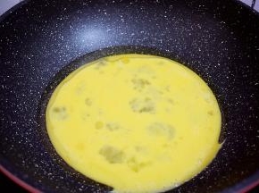 锅中倒入适量的食用油烧热，倒入鸡蛋液，用筷子快速搅拌成鸡蛋小碎块