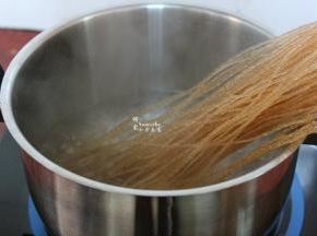清水煮沸，放入薯粉。挑选薯粉要选择纯红薯粉做得，劲道爽滑，味道好，营养高。