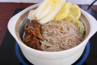 把汤锅的薯粉捞到瓦煲，然后方式卤肉、卤肉汤汁、油、大白菜，一起大火煮沸，转为中小火炖6分钟。