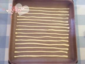 28*28烤盘铺油布，裱花袋剪个小口，挤入条纹图案。放入烤箱，165度烤2分钟定型。