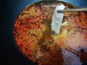然后把腌制好的肉片展开，一片一片放入锅中烫熟