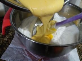 然后把拌均匀的蛋黄糊打倒入到余下的蛋白霜内,再次翻拌均匀。