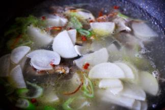 这个时候把切薄的萝卜片放入锅中。