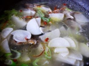 这个时候把切薄的萝卜片放入锅中。