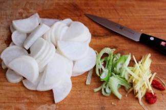 洗净后的白萝卜用刀切成薄片，葱姜切成丝备用。