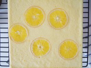 烤好的蛋糕片扣在晾网上，撕掉油布后盖上一张油纸，晾至温热