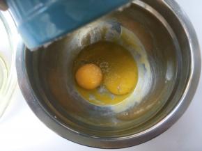 将焗碗内多余的细砂糖倒入蛋黄中
