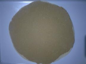 把两块面团重叠在一起，继续擀成厚度为1mm左右的薄饼