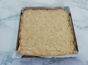 烤盘中垫上油纸，把发酵好的面团均匀的摊在烤盘中