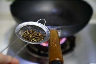 预热锅，这是朋友送来的无涂层高纯度蓝铁炒锅，朋友们可以了解一下，锅里加油微热，将花椒过水之后下锅煸炒出味。