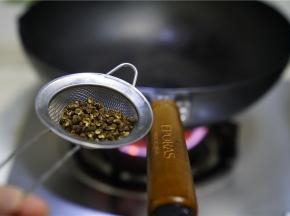 预热锅，这是朋友送来的无涂层高纯度蓝铁炒锅，朋友们可以了解一下，锅里加油微热，将花椒过水之后下锅煸炒出味。