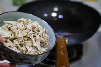 然后将花椒控出，将肥肠改刀下锅煸炒微干。